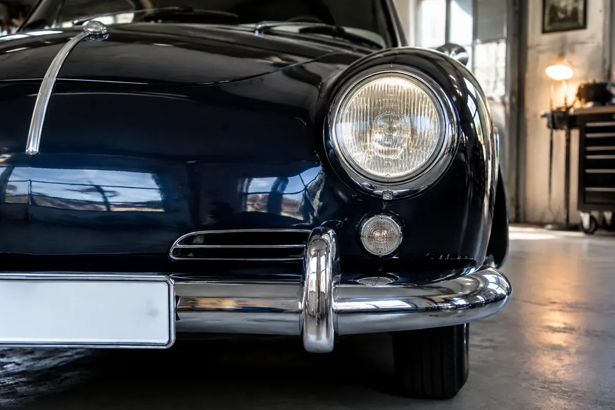Dunkelblauer Oldtimer mit Chromstoßstange und leerem Kennzeichenhalter